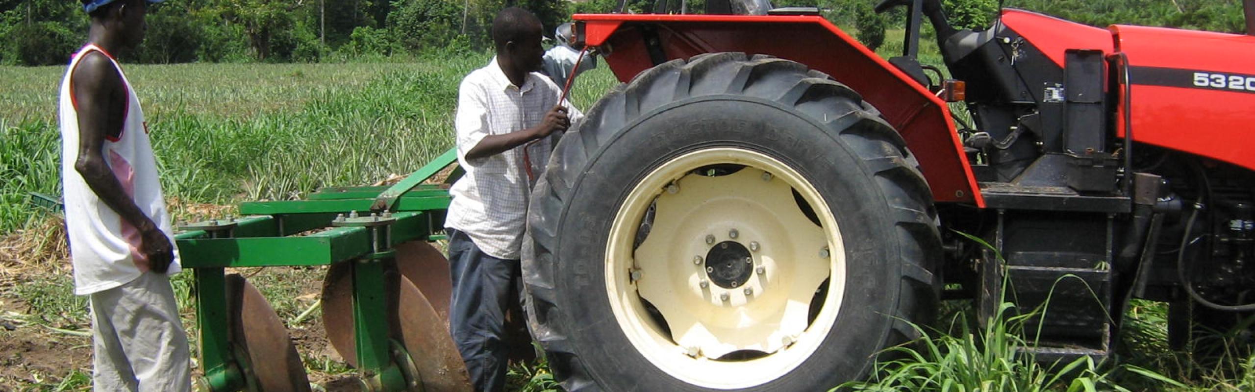 Ghanaian farmers work on tractor