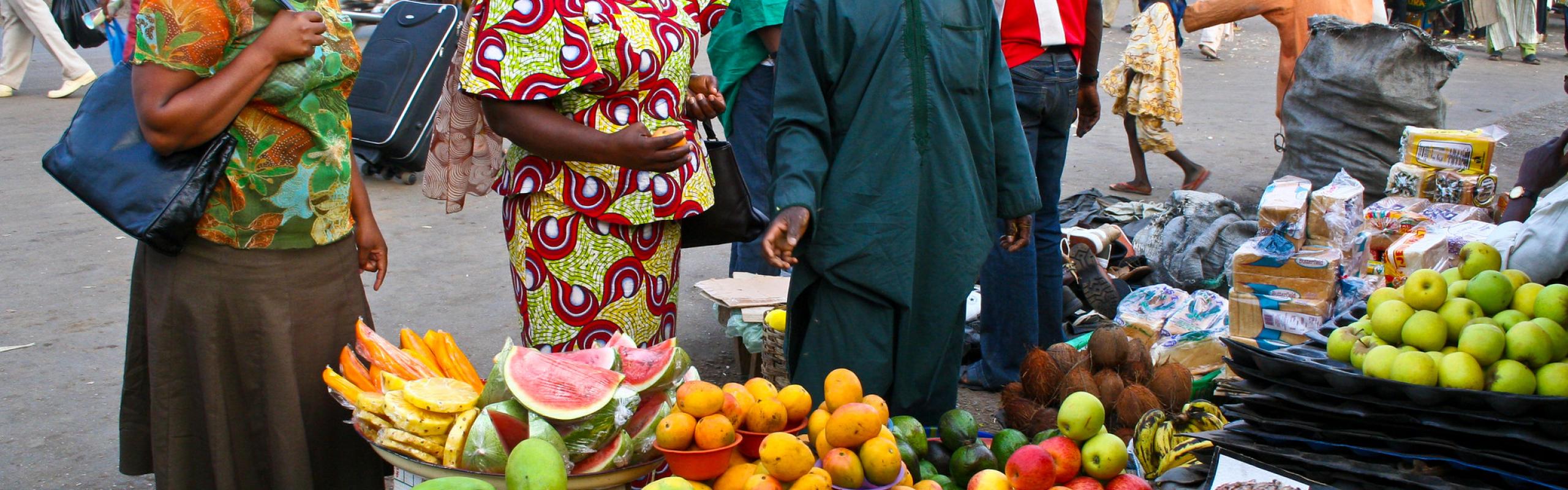  Les acheteurs se tiennent à l'étal dans le marché des fruits nigérian