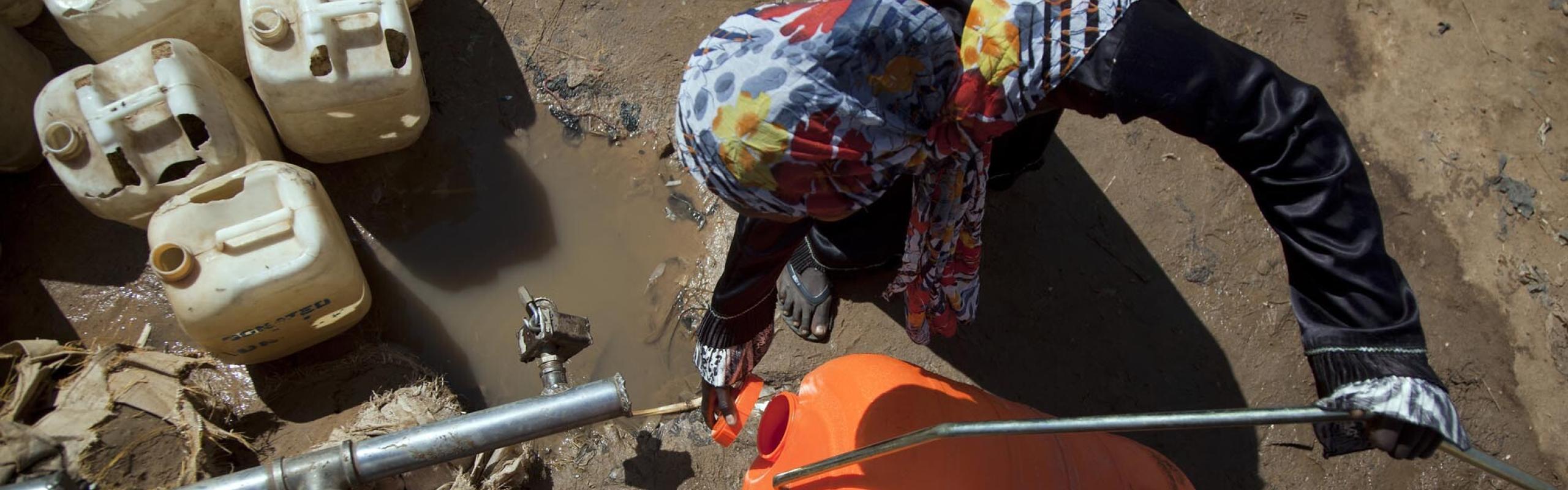 omen filling a Water Roller in a water point in Sudanese camp for internal displaced people. Conflict and extreme weather shocks continued to drive acute food insecurity in 2021.