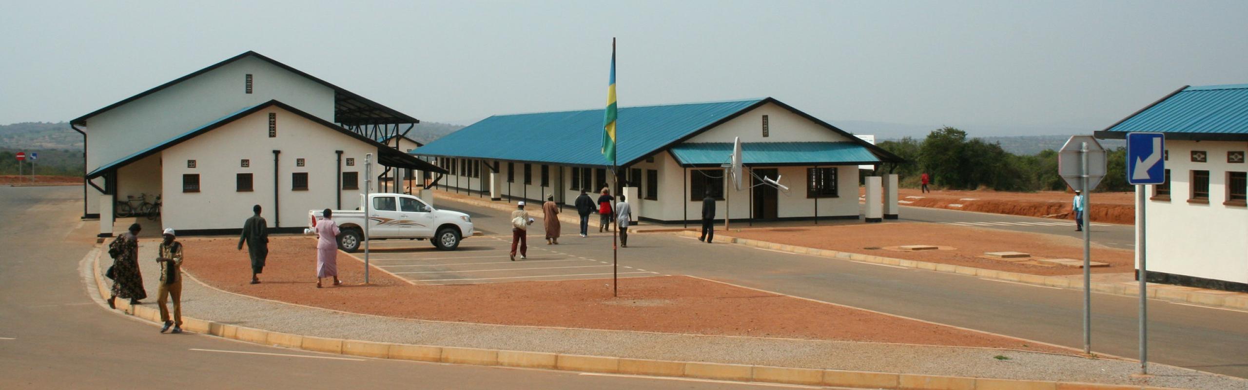 People walking outside customs buildings at the Burundi-Rwandan border.