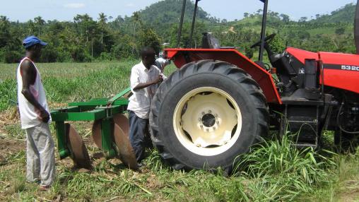 Ghanaian farmers work on tractor
