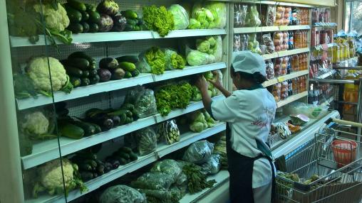 Un travailleur organise des légumes sur une étagère dans un supermarché à Addis-Abeba, en Éthiopie