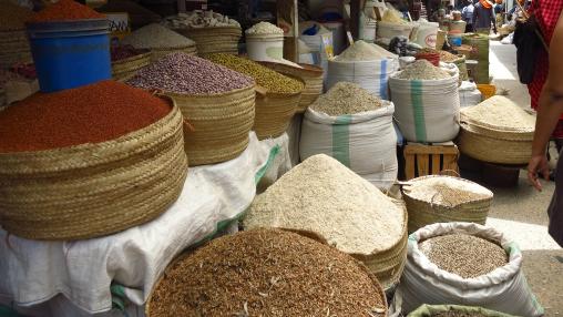 Des tas de céréales, de légumineuses et d'épices dans des sacs en tissu sur un marché en plein air en Afrique