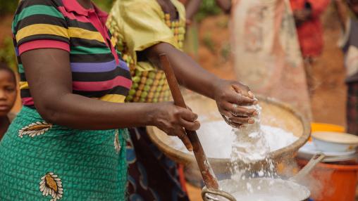Women preparing a communal meal hand sift maize flour into a cookpot in a Malawi village. Rising global maize prices may impact the country's poor population.