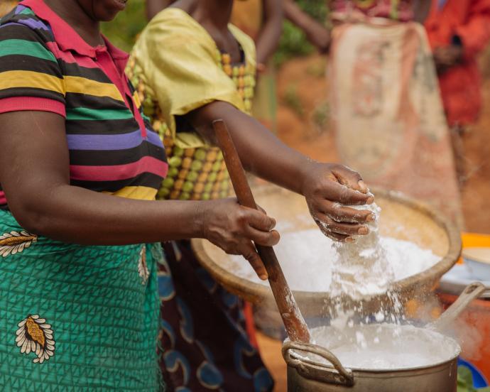  Des femmes préparant un repas commun tamisent à la main de la farine de maïs dans une marmite dans un village du Malawi. La hausse des prix mondiaux du maïs pourrait avoir un impact sur la population pauvre du pays.